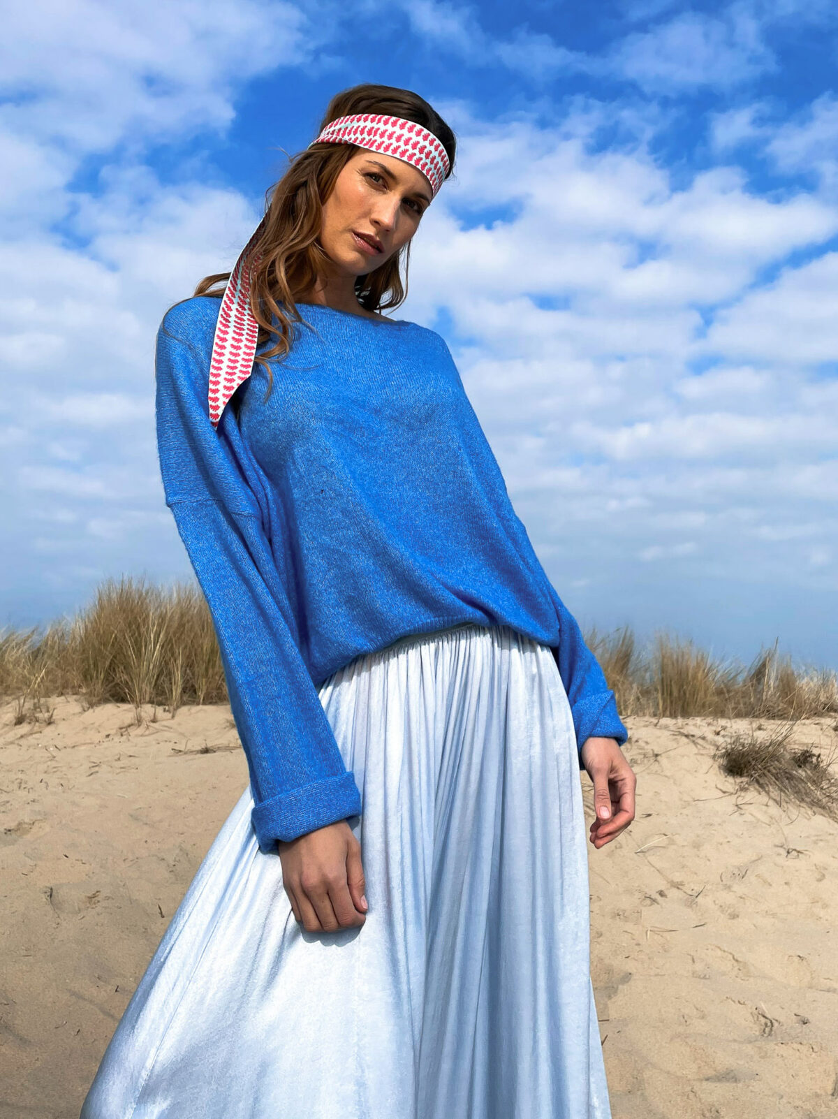 woman with a blue knitted sweater and a blue satin skirt