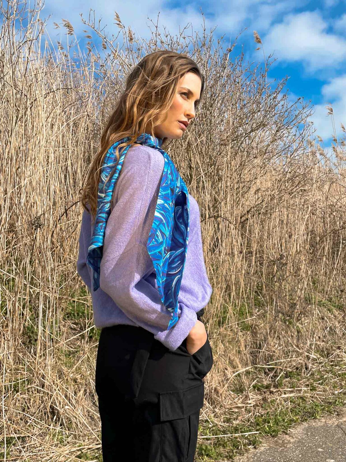 woman with a blue scarf and a lilac knitted sweater