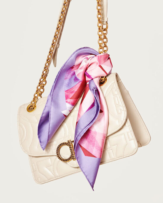 white purse with a pink and purple scarf