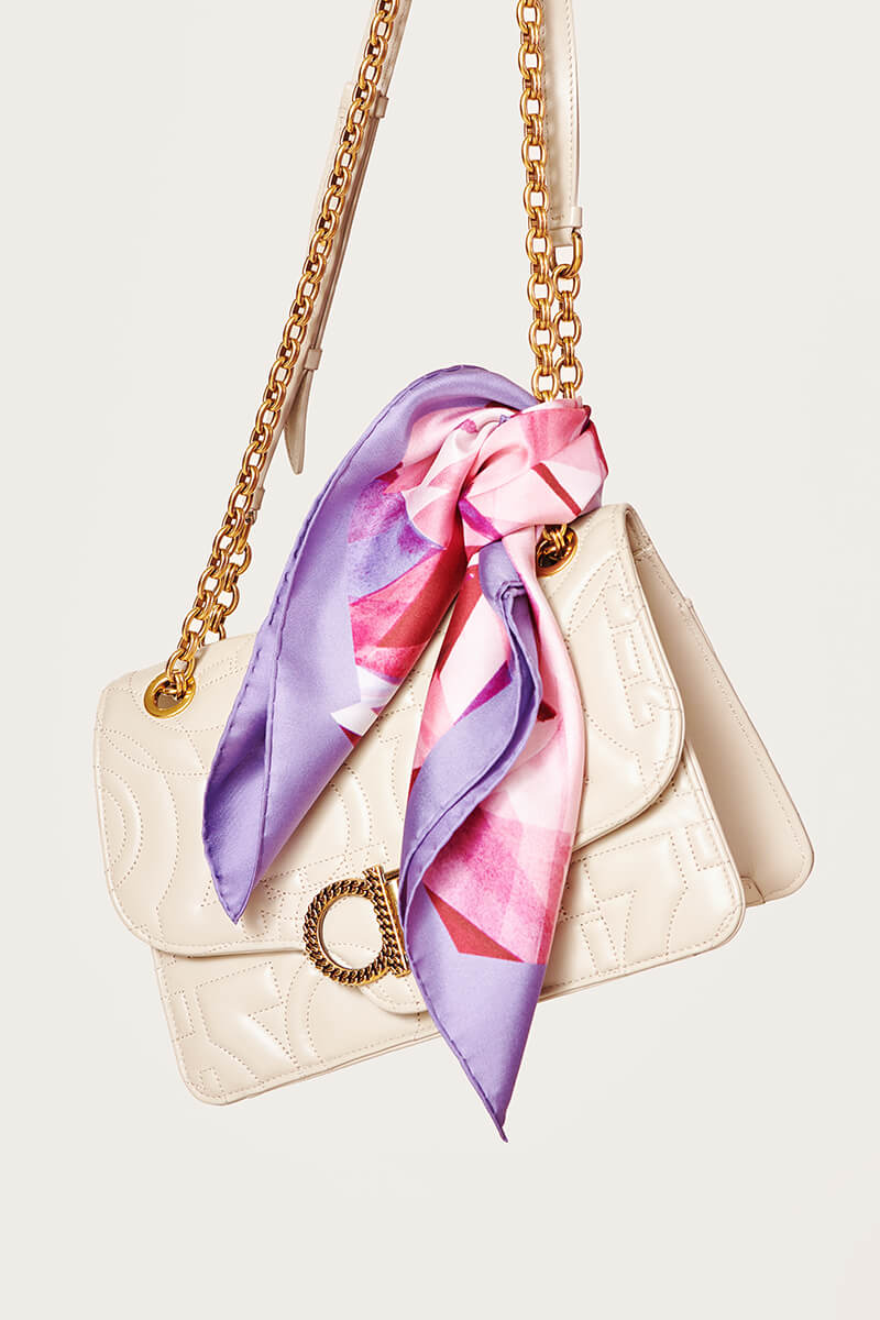 white purse with a pink and purple scarf