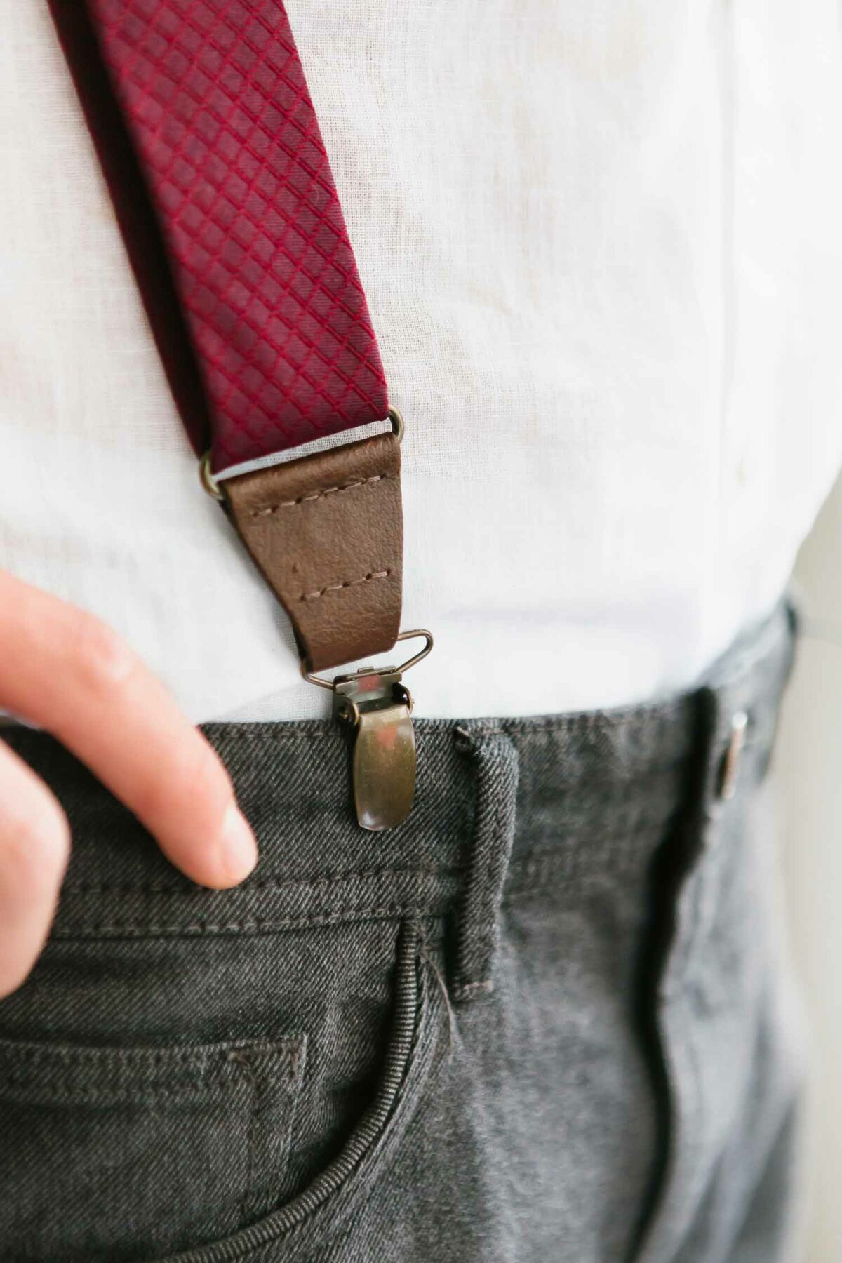man with red bordeaux suspenders