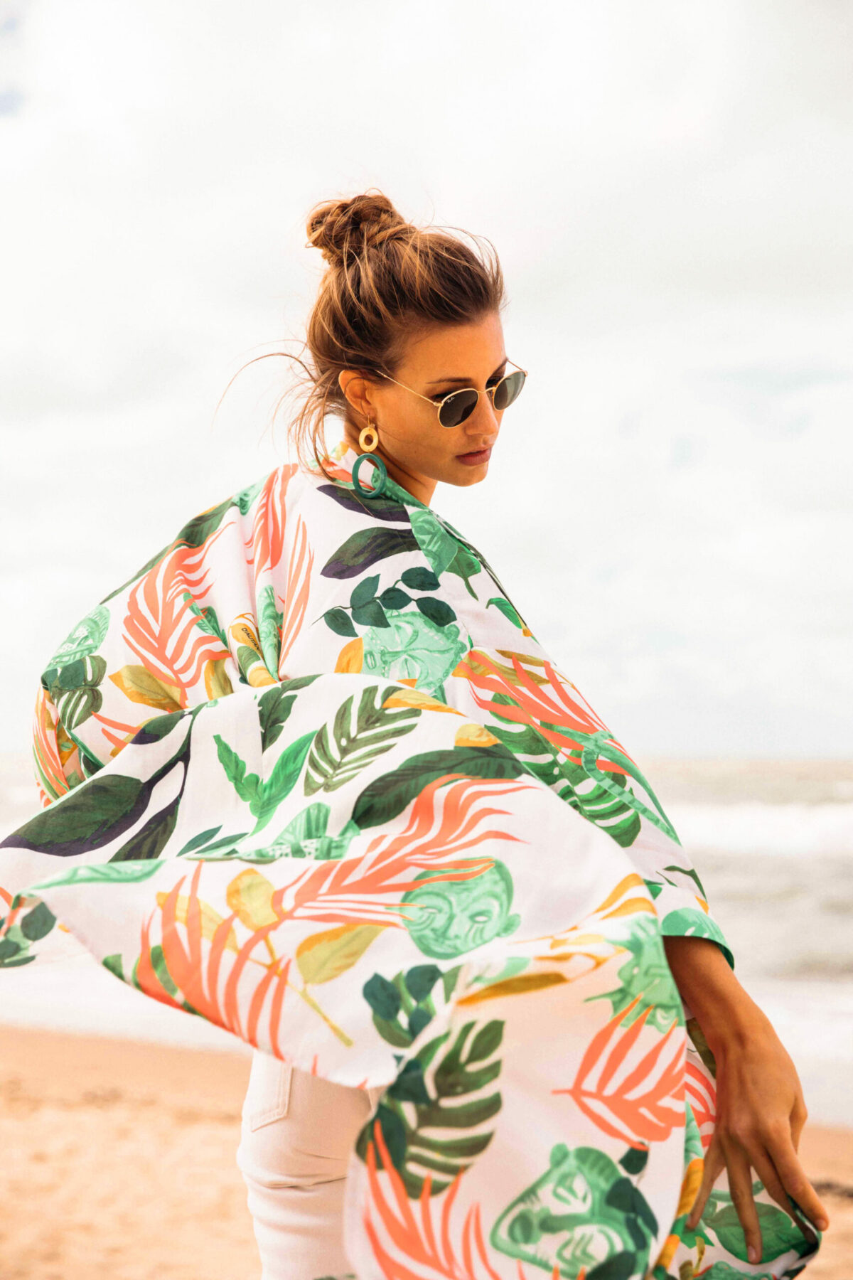 woman on the beach wearing a green white and orange kimono
