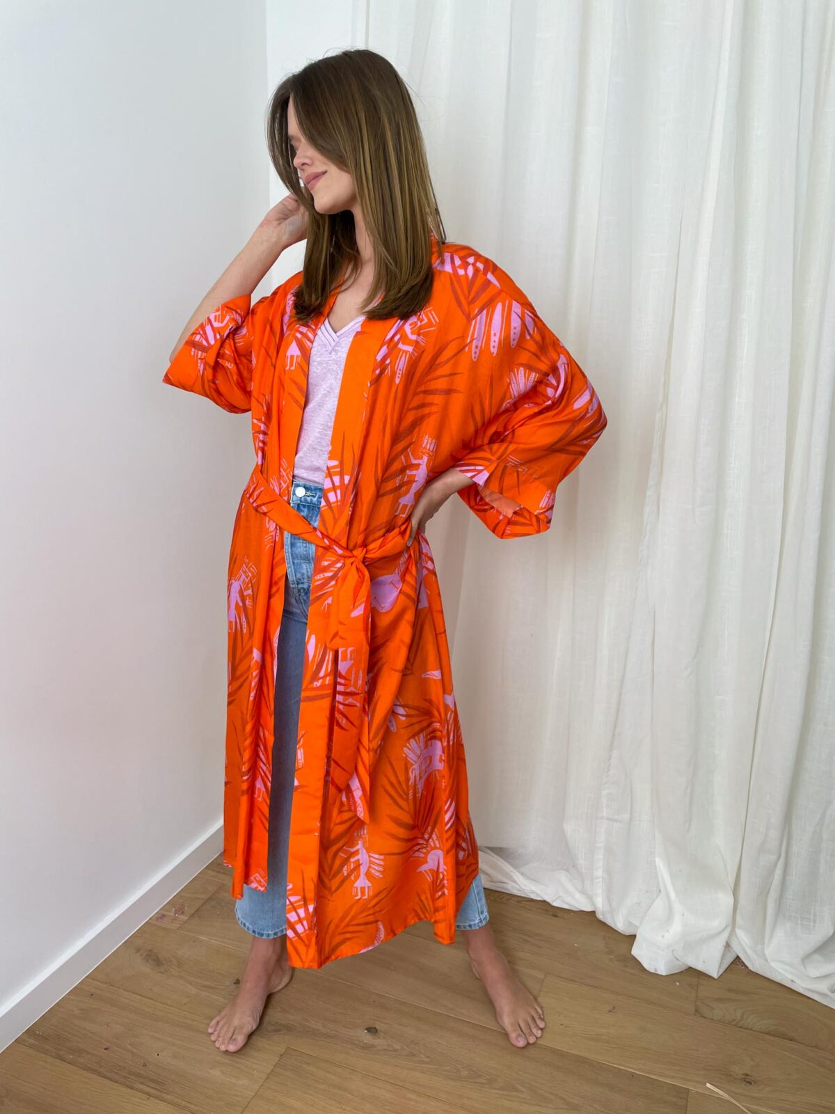 woman with an orange kimono and denim pants